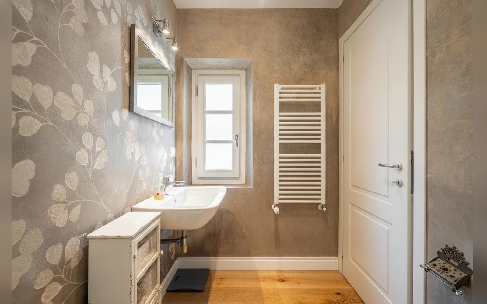 Il bagno con la carta da parati a foglie e lo scaldasalviette